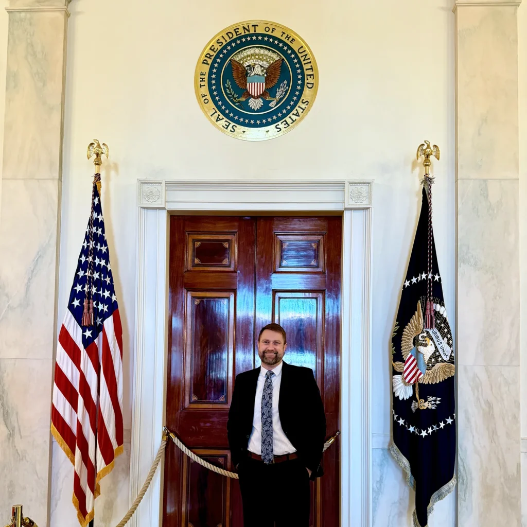 Jonathan Keller stands beneath the presidential seal at the White House in 2026.